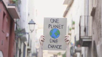 Demonstrator on the city protesting against climate change and pollution - Global warming and environment concept - Focus on banner