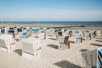 Fototapeta na wymiar Wide sandy beach on the North Sea with beach chairs. Beach by the sea in Holland, Germany or Denmark. dunes by the sea