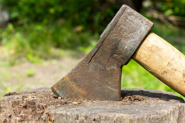 An ax sticking out of a log. Preparation of firewood.