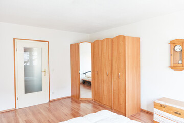 Furnished bedroom with corner wardrobe and mirror