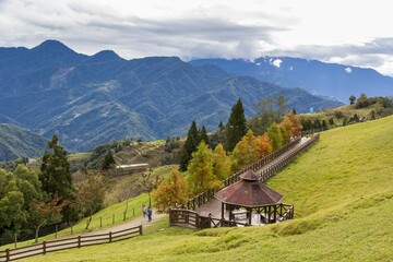 Beautiful landscape of Qingjing Farm in Taiwan with green hills in the background and wooden walkway