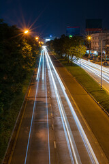A vertical view of the car lights from a long exposure in a street photography with street lights.