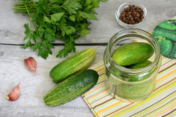 canned cucumbers in jar with garlic, black pepper and parsley