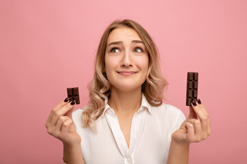 Young female choosing between pieces of chocolate