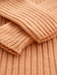 Fototapeta na wymiar Biege knitted textile jumper with sleeves, sunlight, close-up, vertical photo