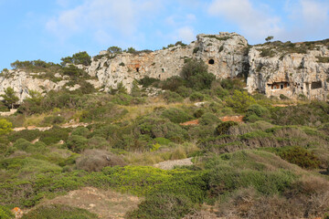 Fototapeta premium Cuevas junto a la playa de Son Bou, en la isla de Menorca. Cuevas junto a la basílica paleocristiana de Son Bou, que son utilizadas como viviendas. Islas Baleares, españa.