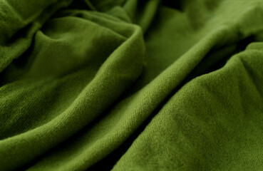 Green woolen natural texture, knitted textile abstract background, close-up