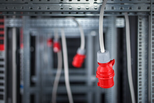 Cables with industrial 32A 5PIN plug connector (IEC 60309, IEC 309 or CEE 17) hanging in the construction of the upcoming server rack.