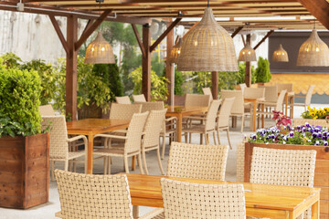 Outdoor cafe with wicker furniture and lamps. Focus on the chandelier