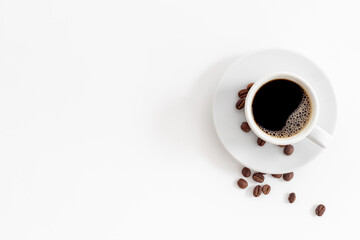 White cup of hot black espresso with coffee beans