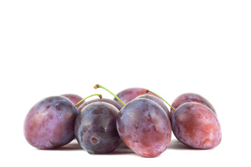 Pair of purple Plums with leaf isolated on white background.