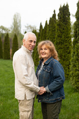 Obraz premium mature senior smiling couple hugging outside in autumn or summer nature in park