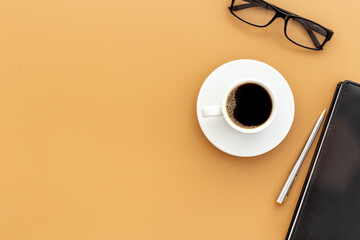 White cup of hot black coffee with glasses and notepad. Coffee break time concept