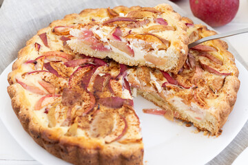 American classic sour cream pie with apples on a white wooden background