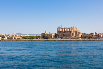 Fototapeta na wymiar Catedral de Palma de Mallorca vista desde el mar, junto al palacio de la Almudaina, el parque del Mar y con el dique frente a ellos. Islas Baleares, España.