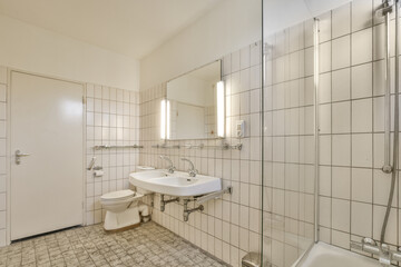Bathroom with white tiled walls near sink in light