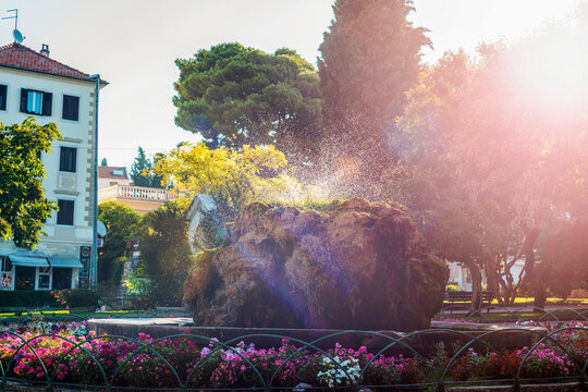 Moss covered stone fountain in the park Lujo Maruna in sunlight. Sibenik, Croatia