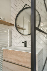 Shower faucets attached to tiled wall near glass partition and ornamental curtail in washroom at...