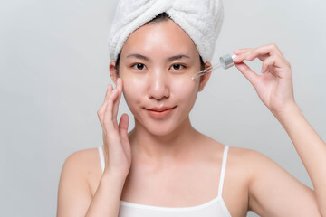 Asian woman is stopping skin serums for her face to make skin soft, moisturized, white and clear.