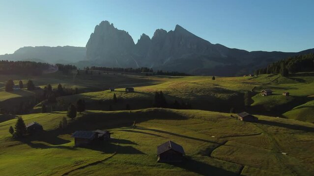 Seiser Alm Alpe di Siusi at Summer in Italian Dolomites, South Tyrol Trentino Alto Adige, Italy. Alpine green meadow, wooden cabin hut. Sassolungo and Sassopiatto mountains.