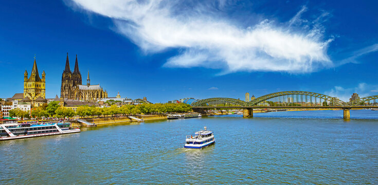Beautiful panoramic skyline view, scenic river rhine sightseeing boat cruise, dom and church, Hohenzollernbr&uuml;cke, Hohenzollern bridge, spectacular clear blue summer sky, Cologne, Germany