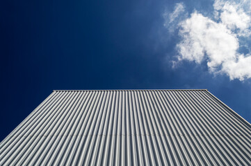 Fototapeta na wymiar Dark blue sky and building facade in Belo Horizonte. A cloud. Space for advertisement.