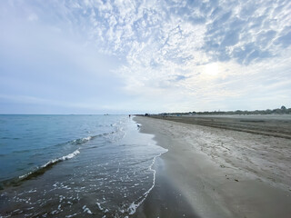 Seashore landscape. Summer holiday destination in Italy. Sandy beach in sunlight.