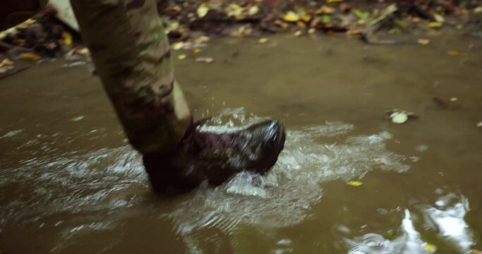steps on the water in the river. wet berets of a soldier in camouflage walk along the river. dirty water. breezes. footsteps of an Urkanian soldier