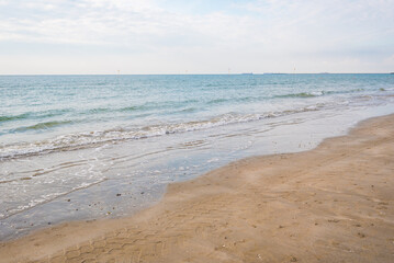 Fototapeta na wymiar Seashore landscape. Summer holiday destination in Italy. Sandy beach in sunlight.