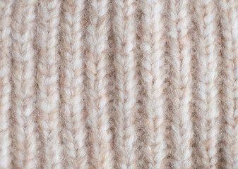 Beige knitted woolen fabric texture background. Autumn or winter season, sale. Top view, closeup, macro