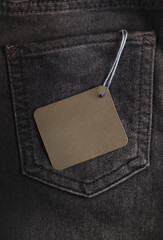 Jeans pocket with blank card for text or label. Black Friday, sale concept. Top view, closeup, copy...