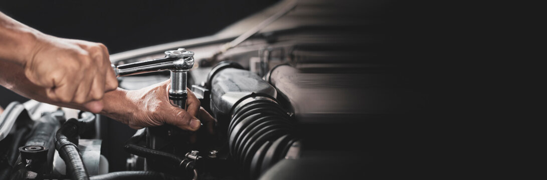 Car mechanic working on car engine, car maintenance concept.