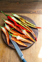 cut pods of red hot pepper on a wooden board
