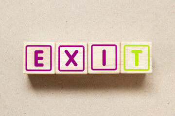 Color letter block in word exit on wood background