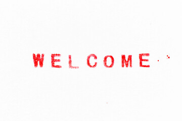 Red color ink rubber stamp in word welcome on white paper background