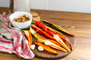 cut pods of red hot pepper on a wooden board