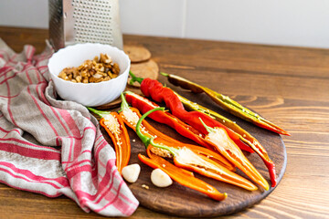 cut pods of red hot pepper on a wooden board