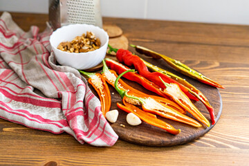 cut pods of red hot pepper on a wooden board