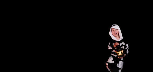 Halloween. boy in a suit with a lantern, black background, copy space