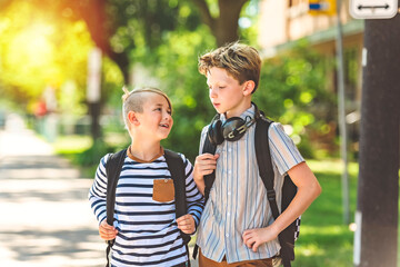 Two Elementary school boys outside carrying a backpack