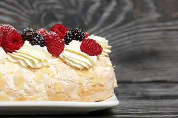 Meringue roll with mascarpone cream. Garnished with raspberries and almond petals. Close-up.