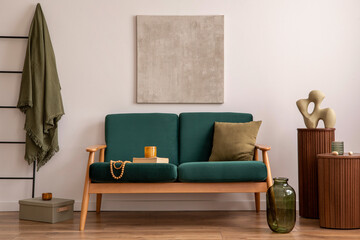 Classic space of living room with mock up poster, bottle green sofa, wooden coffee table and personal accessories. Beige wall. Home decor. Template.