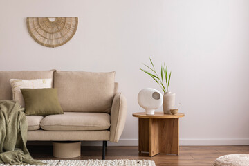 Minimalist composition of elegant and outstanding space with beige sofa, coffee table, vase, green...