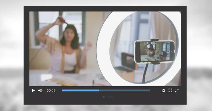Animation of social media screen over caucasian woman making video blog at home