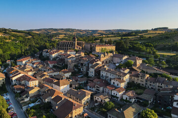 Fototapeta premium Early morining aerial sunrise shot of Saint-Antoine-l'Abbaye the Morning of the summer médiéval festival