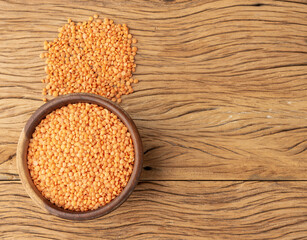 Orange lentil on a bowl over wooden table with copy space