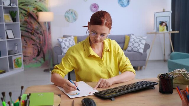 shoe design, talented woman draws shoe print on paper while sitting at computer in modern apartment