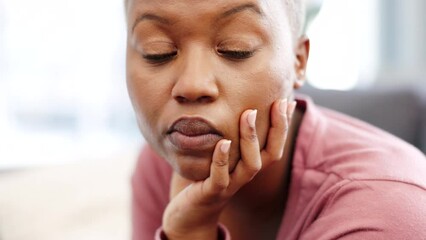 Black woman sad, anxiety and depression while on the sofa in home in the living room. Burnout, stress and lonely girl with mental health, psychological or frustrated with life problem while thinking