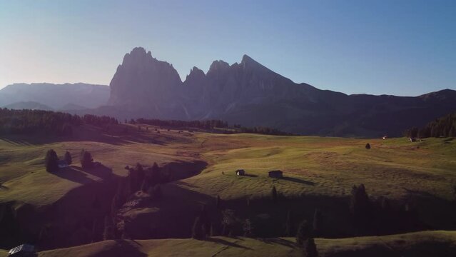 Seiser Alm Alpe di Siusi at Summer in Italian Dolomites, South Tyrol Trentino Alto Adige, Italy. Alpine green meadow, wooden cabin hut. Sassolungo and Sassopiatto mountains.