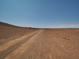Fototapeta na wymiar Gravel road through the arid region of the Damarland Namibia